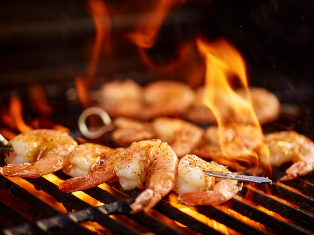 shrimp cooking over a wood fired grill