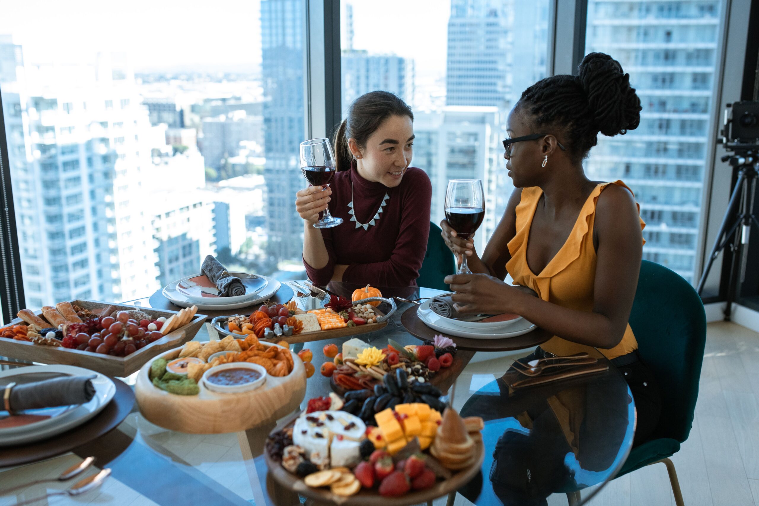 two female friends enjoying a meal in a high-rise building